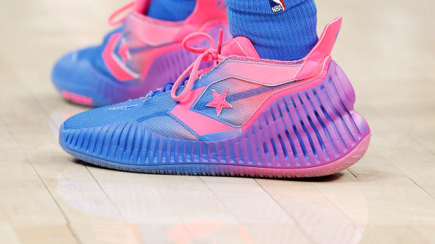 View of pink and purple Converse shoes.